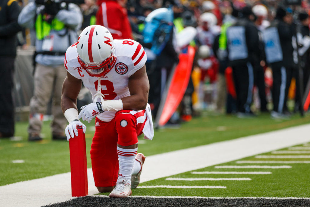 football player kneeling in prayer